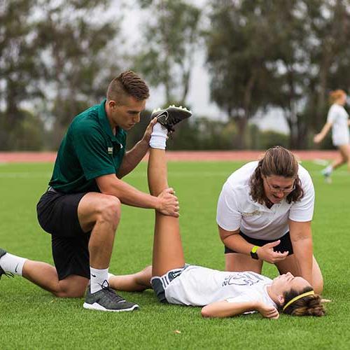 Athletic training student stretching an athlete.